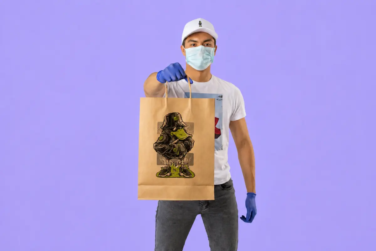 Person holding a paper shopping bag with a DTF printed graphic design, demonstrating printing on non-fabric materials