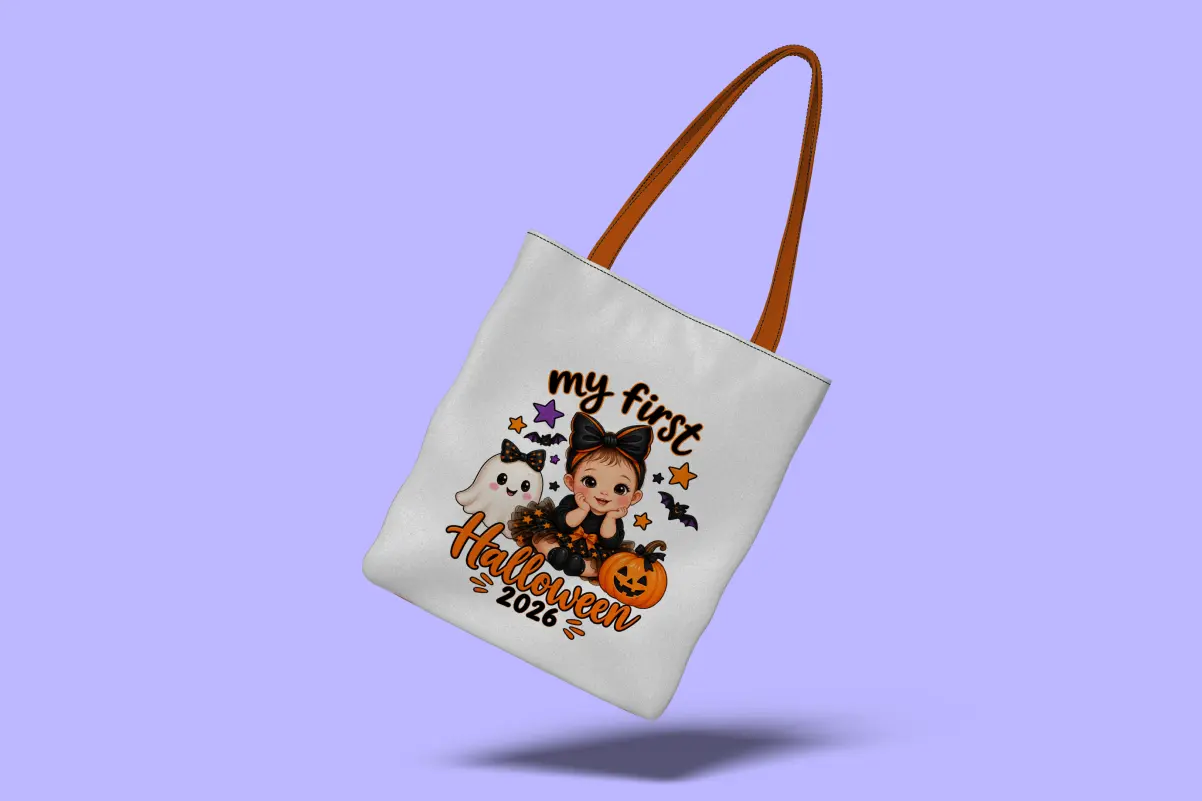 White tote bag with orange straps, printed with "My First Halloween 2026" text and a cartoon baby in a bow, ghost, pumpkin, bats, and stars design